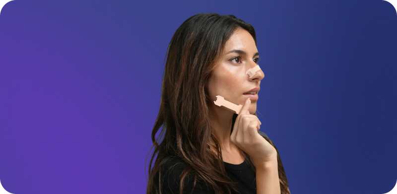 Woman using breathe nasal strip on a blue background