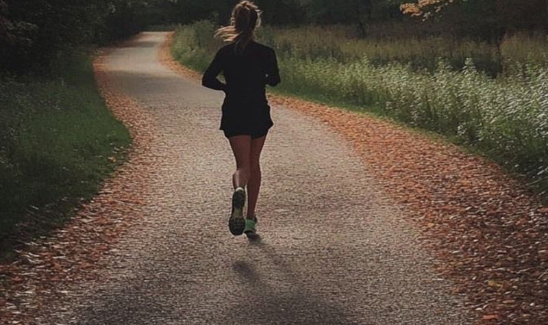 Person running on a path surrounded by nature